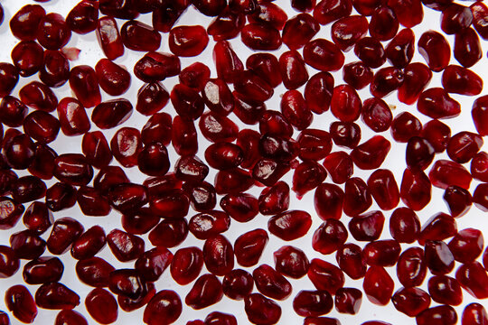 Pomegranate seeds macro texture background. Red ruby pomegranate arils close up texture. Pomegranate arils texture. Pomegranate seeds detail for texture.