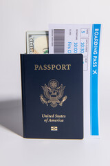 US passport with boarding pass and dollars on white. Travel documents for airport check in and international flight concept. American passport and money theme. Boarding pass and payment card. © Svitlana