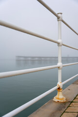 Fototapeta premium Fog on the Huelva Estuary. Odiel River. In the background, the old pier of the Tinto mining company. Living history of the city