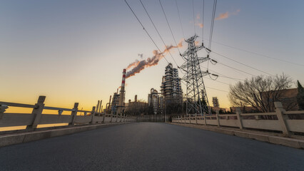 Industrial Plant with Power Transmission Towers at Sunset
