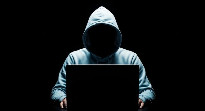 Person wearing a hoodie using a laptop in a dark room with a mysterious atmosphere and a sense of anonymity and cybersecurity - Powered by Adobe