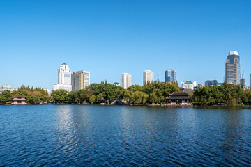 Obraz premium Urban Skyline with Lake and Traditional Pavilions