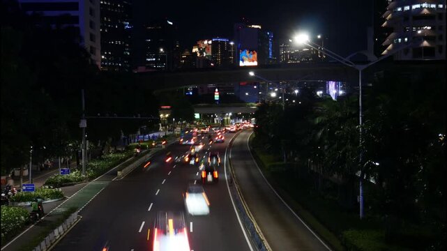 Night Timelapse of Busy Traffic Light Trails and City Lights at Sudirman Business District