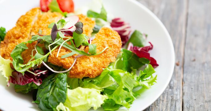 Salad with pork cutlet on a plate