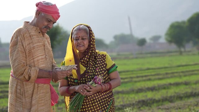 senior indian farmer couple holding cash in hand 