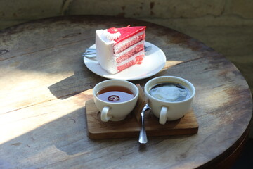 Cake and hot coffee on a wooden table.