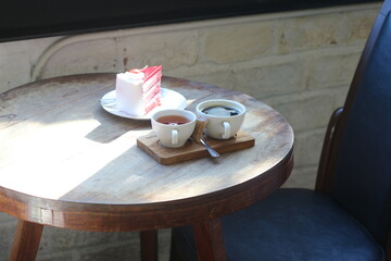 Cake and hot coffee on a wooden table.