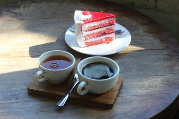 Cake and hot coffee on a wooden table.
