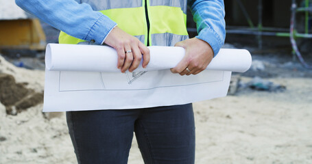 Hands, blueprints and woman with construction site, architecture and inspection for project. Closeup, person and worker with documents, engineering or urban development with floor plan or real estate