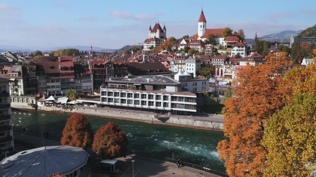 Schloss Thun Flusswelle Aare River sunny blue sky clouds Thun Castle Thunersee Switzerland Schweiz Europe aerial drone Autumn Fall season cityscape neighborhood Bernese Oberland backwards pan up