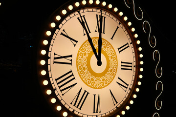 Vintage clock with Roman numerals showing midnight time close-up