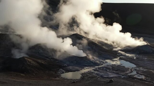 Desolate Volcanic Panorama An expansive drone shot showcasing a vast volcanic landscape with multiple fumaroles contributing to a widespread, hazy veil that drifts over jagged terrain and mineral