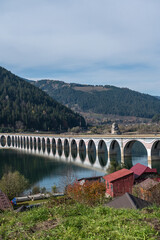 Scenic Arched Viaduct Crossing Lake Izvorul Muntelui In Romanian Mountains