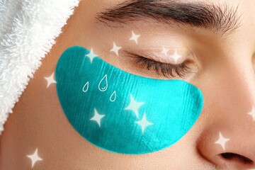 Person applying under-eye mask while relaxing at spa during day