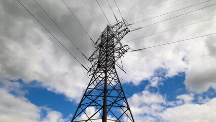 A High Voltage Power Transmission Tower Standing Tall Under a Dramatic Cloudy Sky Above