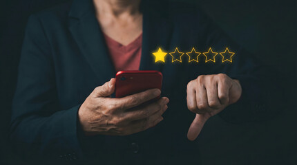 Person holds red smartphone with thumbs down gesture showing one star rating on a dark bac