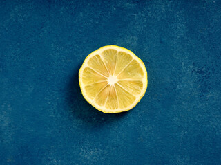 Lemon slice on blue background creating vibrant contrast