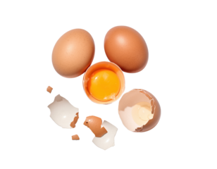 Two whole brown eggs and one cracked egg with yolk and shells scattered around on a ready for compositing on white and transparent background