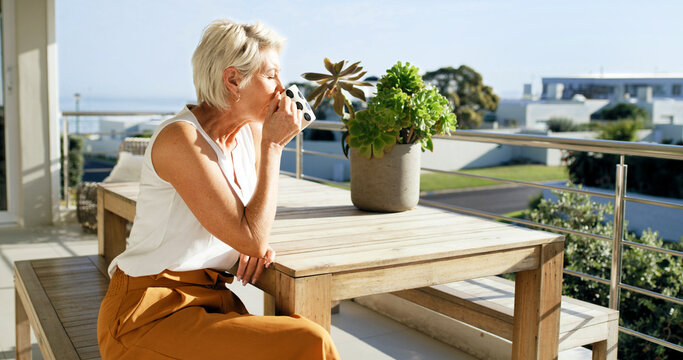 Home, woman and relax with coffee on balcony for calm morning, sun basking and weekend break. Peaceful, mature person and drinking beverage outdoor at house for fresh air, start day or summer holiday