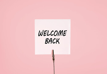 Welcome back message handwritten on white note card