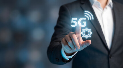 Businessman points at glowing 5G icon with Wi Fi and gear symbols on a dark background