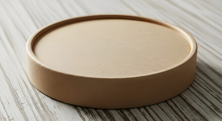 A round, beige, plastic container lid on a wooden surface