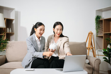 Businesswomen discussing financial planning and saving money using piggy bank at home office. Investment, budget, teamwork, female leadership