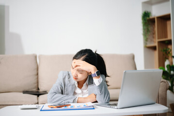 Stressed Asian businesswoman working alone at home office. Burnout, work stress, financial problem, fatigue and pressure from business deadline