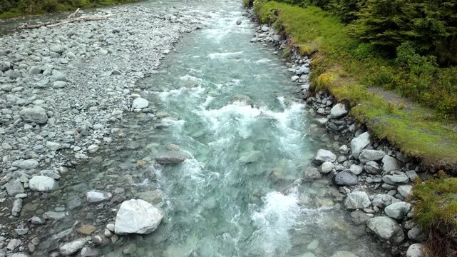 Aerial view of clear river rapids over stones and gravel