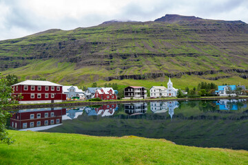 Icelandic landscape, view of Seydisfjordur with houses and reflecting in sea fjord lake water, Iceland