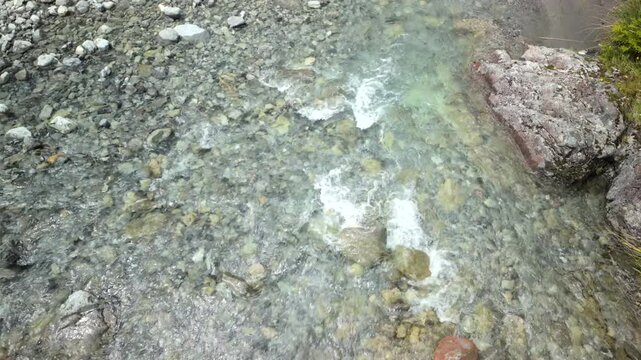 Clear shallow stream over pebbles and rocks top view