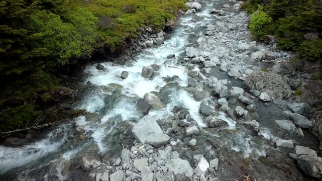Fast mountain stream rushing over rocks in narrow riverbed