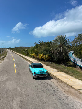 Vintage classic car driving on coastal road in Cayo Guillermo Cuba