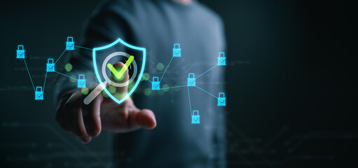 businessman touching digital security shield with check mark, representing cybersecurity protection, data verification, network safety, secure technology system, online privacy, risk management.