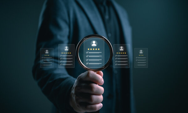 Businessman holding magnifying glass selecting top rated profile with five star review, representing talent recruitment, candidate evaluation, customer rating analysis, trust, quality selection.