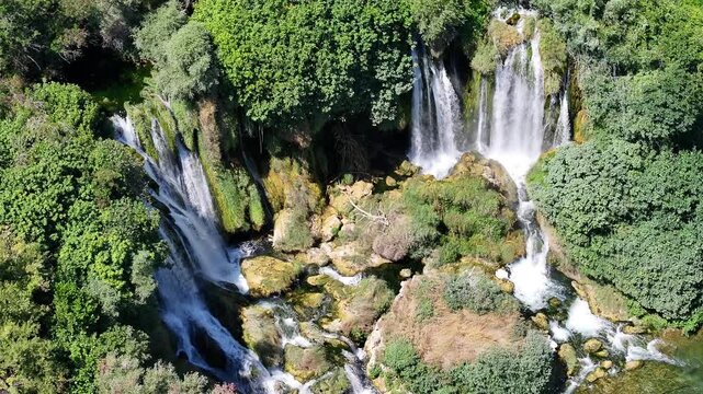 Close aerial footage of Kravica waterfall cascades focusing on continuous water movement and rocky textures