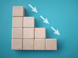 Business decrease concept. Business decreasing white arrows symbol on wooden stairs blocks.