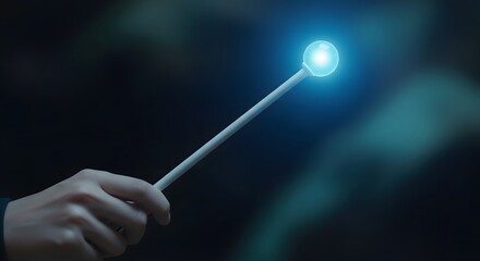 A hand holding a glowing wand with a bright blue light at the tip in a dark background with a mystical atmosphere and magical feel