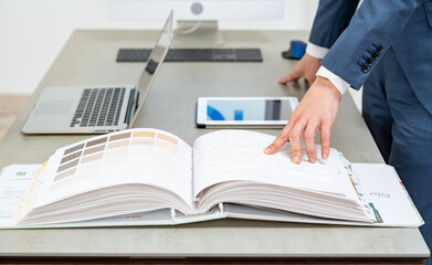 打ち合わせをする作業着、スーツを男性たち