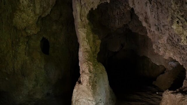 Interior of a cave in V&eacute;lez de Benaudalla. Natural columns, stalactites, and the rough texture of the rock can be seen.