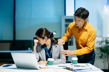 Fototapeta premium Stressed Asian business colleagues working in office, facing deadline pressure, paperwork, anxiety and burnout, business problems, workplace stress and corporate challenge concept.