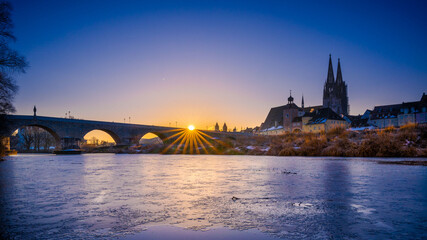 Sunrise over Stone Bridge in Regensburg, Bavaria, Germany in winter with frozen Danube © Robert Ruidl