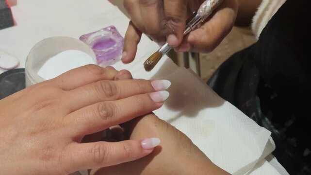 Professional nail extension shaping using a file, highlighting modern beauty techniques and cosmetic precision.