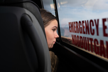 Boy looking out bus window while traveling along coast