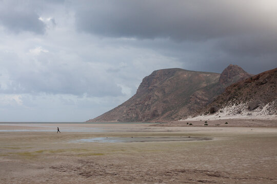 Man running acros a beach alone in Socotra, Yemen