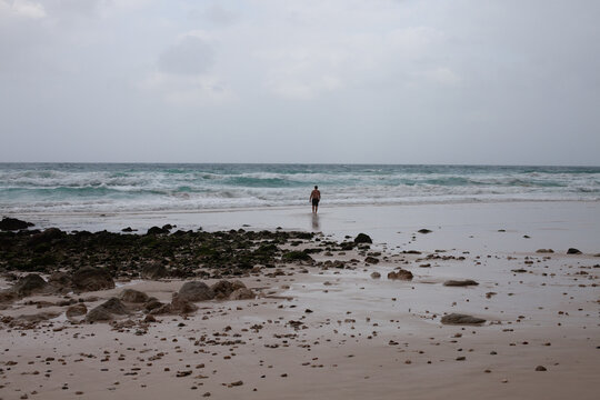 Man walking to the sea on Arher Beach in Socotra
