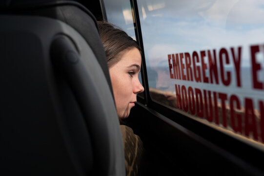 Boy looking out bus window while traveling along coast