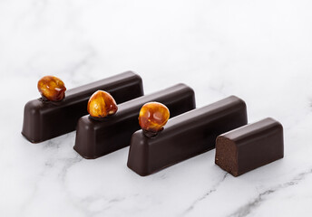 Delicious Chocolate Bars with Hazelnuts on Marble Background