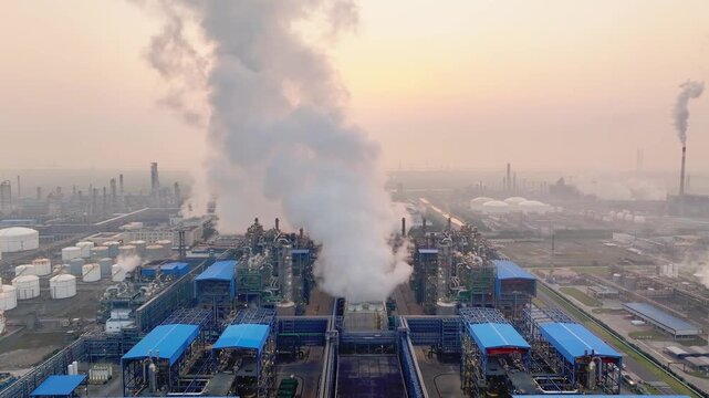 Industrial factory complex emitting thick smoke from chimneys causing air pollution