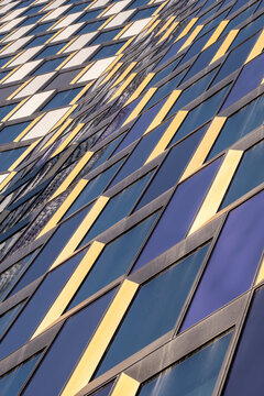Modern abstract architecture skyscraper facade glass reflection on diagonal lines in urban perspective creating bold highrise background texture